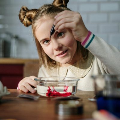 Young girl in kitchen crafting Easter decorations with concentration and creativity.
